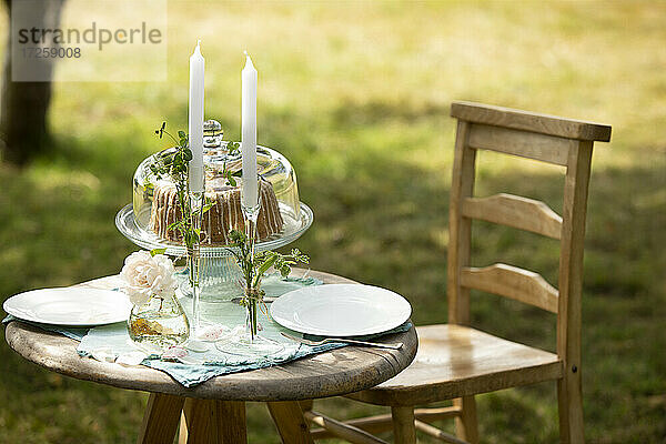 Kerzenständer und Kuchen auf Sommergarten Tisch
