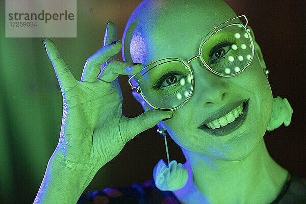 Close up Porträt glückliche Frau mit Retro-Brille in grünem Licht