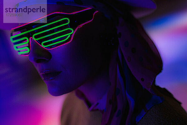 Close up stilvolle Frau trägt Neon-Sonnenbrille in der Dunkelheit