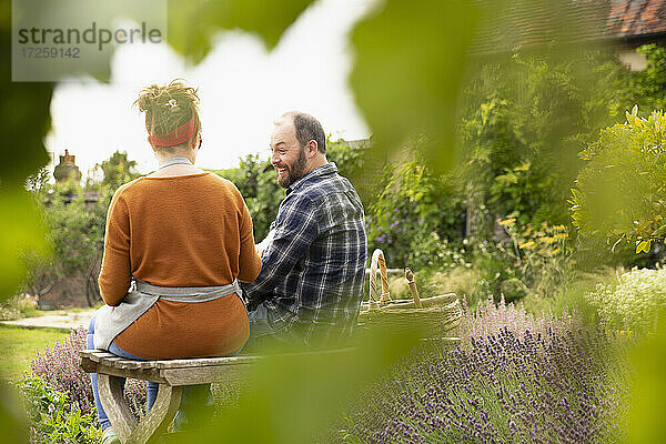 Glückliches Paar nimmt eine Pause von der Gartenarbeit im Hinterhof