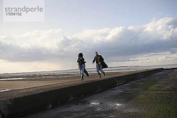 Paar läuft auf Ozean Strand Steg