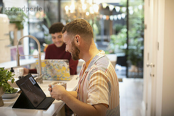 Homosexuell männliches Paar mit digitalen Tablet und Laptop in der Küche
