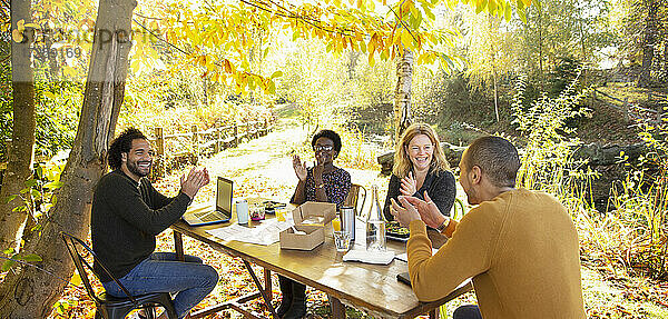 Glückliche Geschäftsleute klatschen und Treffen in sonnigen Herbst Park