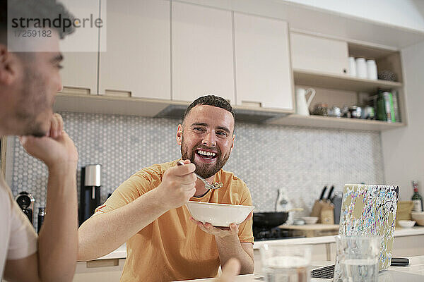 Glücklich Homosexuell männliches Paar Essen in der Küche