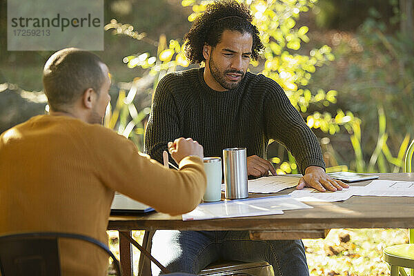 Geschäftsleute besprechen Papierkram am Tisch im Park