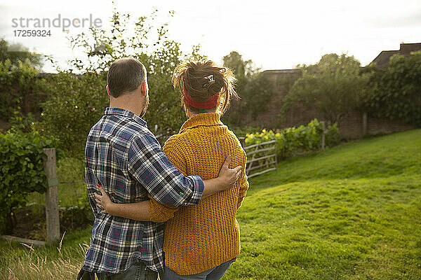 Glückliches Paar umarmt in sonnigen Sommergarten