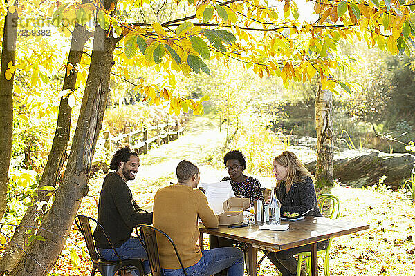 Kreatives Business-Team trifft sich am Tisch im sonnigen  idyllischen Herbstpark