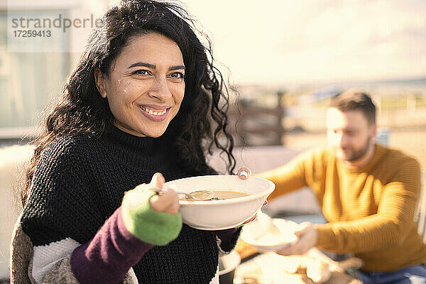 Porträt glückliche Frau Essen auf sonnigen Terrasse