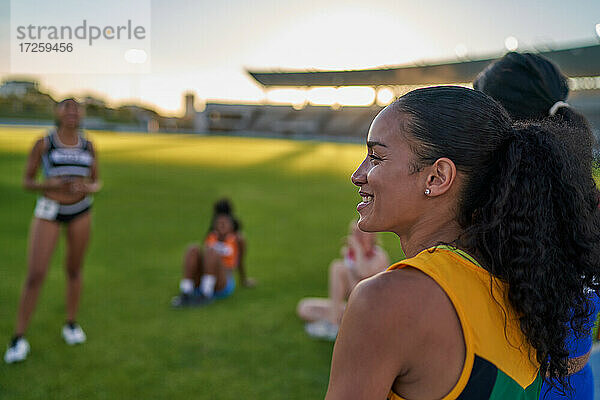 Lächelnde weibliche Leichtathletin im Stadion Gras