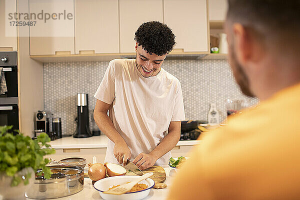 Junger Mann Kochen Schneiden Zwiebel in der Küche