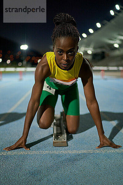 Porträt fokussierte weibliche Leichtathletin am Startblock