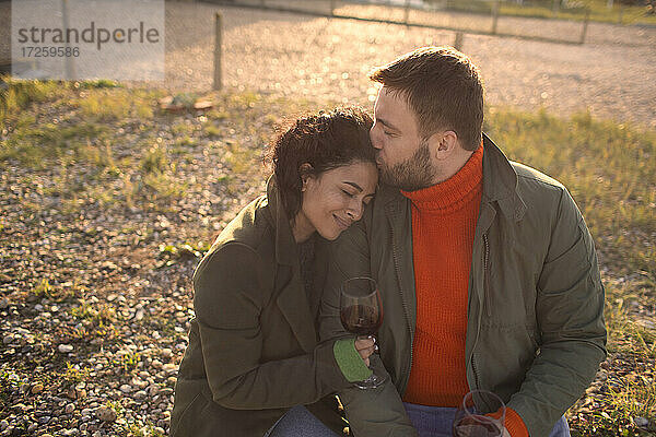 Glücklich liebevolles Paar trinken Wein auf sonnigen Terrasse