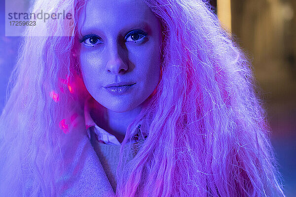 Close up Porträt schöne Frau mit rosa Haaren in Neonlicht