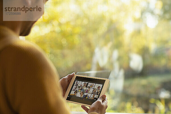Mann Video-Chat mit Freunden auf digitalen Tablet-Bildschirm am Fenster