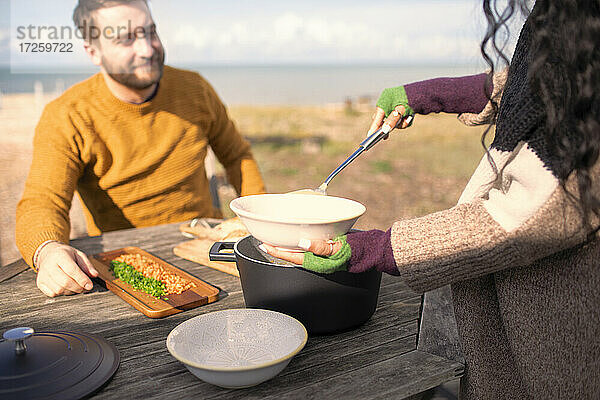 Frau serviert Chowder zu. Freund auf sonnigen Strand Terrasse