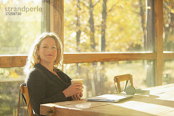 Porträt selbstbewusste Geschäftsfrau mit Kaffee arbeiten im Herbst Cafe