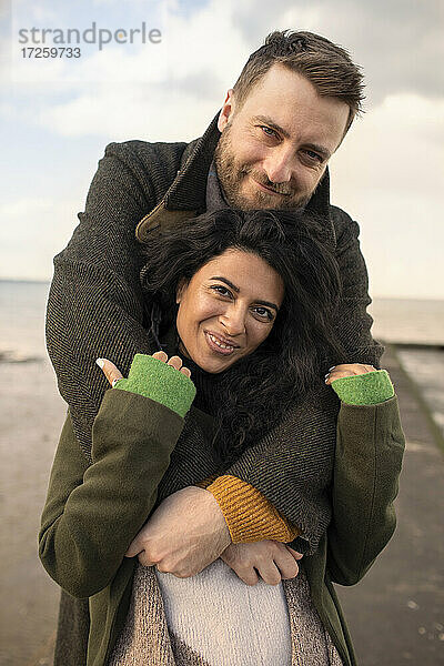 Porträt glückliches Paar in Wintermäntel umarmen