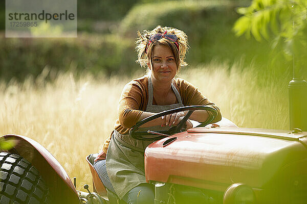 Porträt glückliche Bäuerin fährt Traktor
