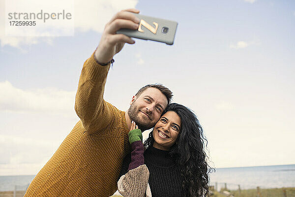 Glückliches Paar nimmt Selfie auf Ozean Strand