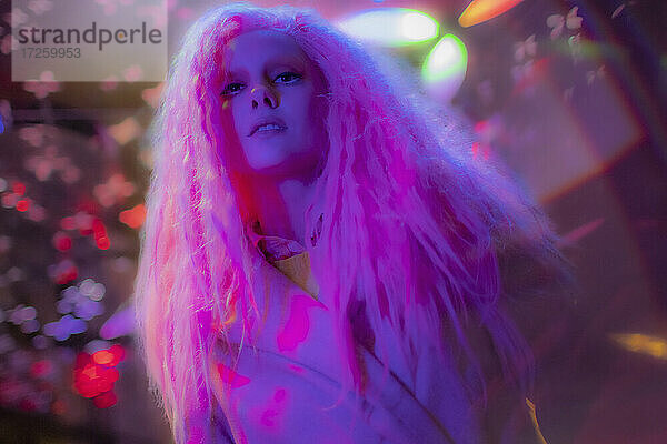 Porträt selbstbewusste Frau mit rosa Haaren im Nachtclub