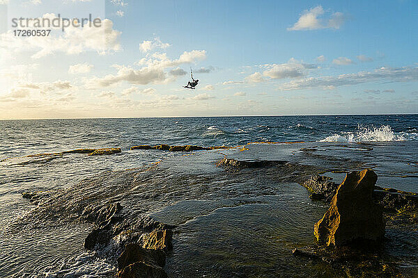 Ein Kiteboarder springt hoch über Felsen bei Montones  Puerto Rico  Karibik  Mittelamerika