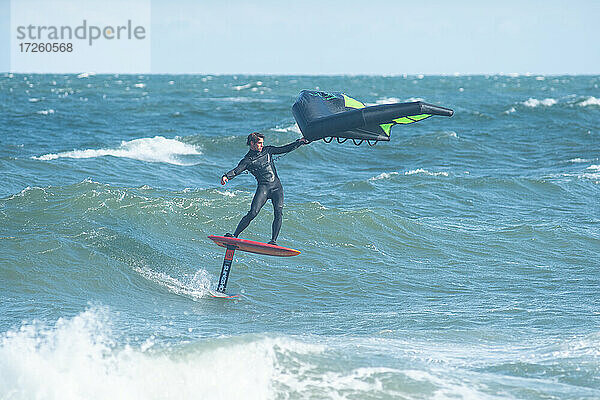Profi-Surfer James Jenkins foilt eine Welle auf seinem Wing-Surfer im Atlantik bei Nags Head  North Carolina  Vereinigte Staaten von Amerika  Nordamerika