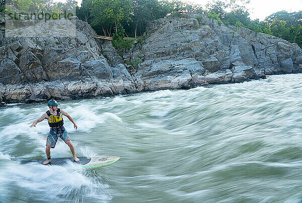 Ian Brown stand up paddle surft anspruchsvolles Wildwasser unterhalb der Great Falls des Potomac River  Grenze zwischen Maryland und Virginia  Vereinigte Staaten von Amerika  Nordamerika