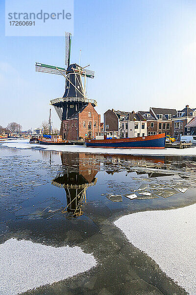 Windmühle De Adriaan spiegelt sich in der Gracht des eisigen Flusses Spaarne  Haarlem  Bezirk Amsterdam  Nord-Holland  Niederlande  Europa