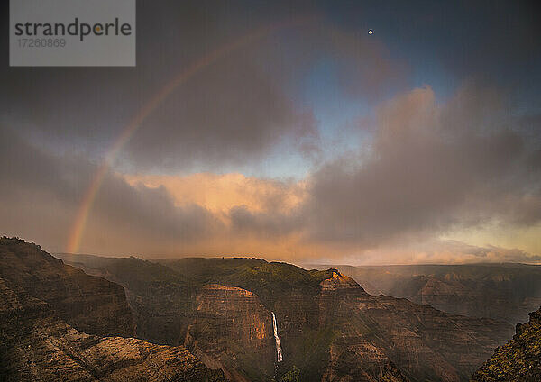 Sonnenuntergang Regenbogen Bögen über den Waimea Canyon und Waipo'o Falls in Richtung des Mondes  Kauai  Hawaii  Vereinigte Staaten von Amerika  Pazifik