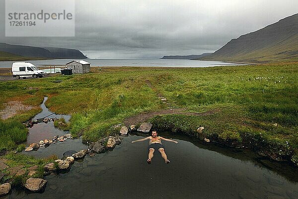 Naturpool am Fjord  Hot Pot  Geothermalquelle  Mann badet Reykjafjarðarlaug  Vestfirðir  Westfjorde  Island  Europa