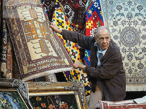 Teppichhändler präsentiert Teppiche im Vakil-Basar  Shiraz  Iran