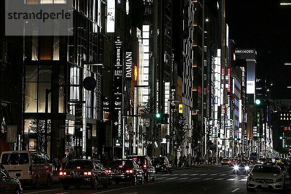 Beleuchtete Straße mit Neonlichtern und Autos im Verkehr im Stadtteil Ginza  Tokio  Japan  Asien