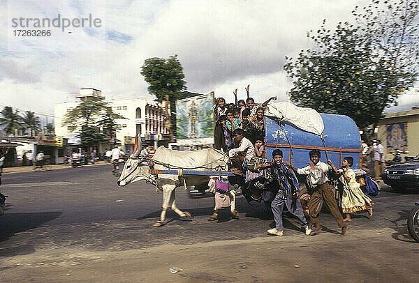 Kinder auf dem Weg zur Schule in einem Ochsenkarren in der Stadt Coimbatore in Tamil Nadu  Indien  Asien