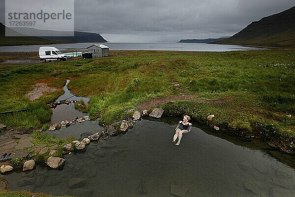 Naturpool am Fjord  Hot Pot  Geothermalquelle  Frau badet Reykjafjarðarlaug  Vestfirðir  Westfjorde  Island  Europa