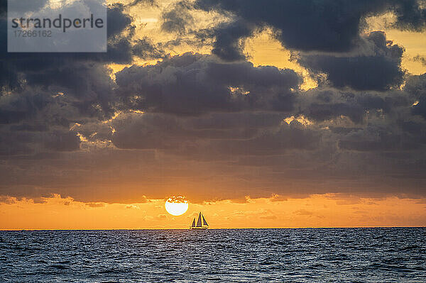 USA  Florida  Boca Raton  Sonnenaufgang über dem Meer mit Silhouette des Segelbootes in der Ferne