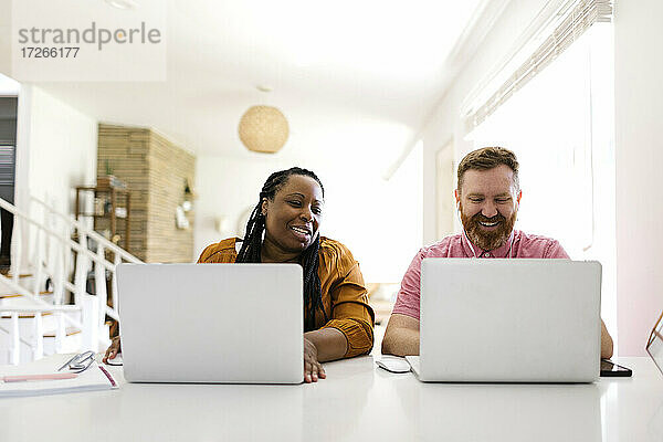 Mann und Frau arbeiten von zu Hause aus an Laptops