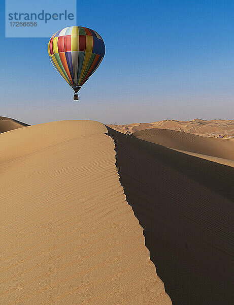 Dubai  Vereinigte Arabische Emirate  Bunter Heißluftballon fliegt über Sanddünen