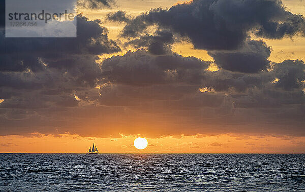 USA  Florida  Boca Raton  Sonnenaufgang über dem Meer mit Silhouette des Segelbootes in der Ferne