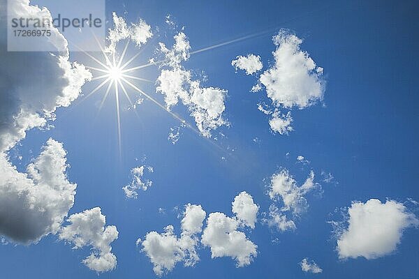 Sonnenstern am blauen Himmel mit einigen Quellwolken im Gegenlicht  Schweiz  Europa