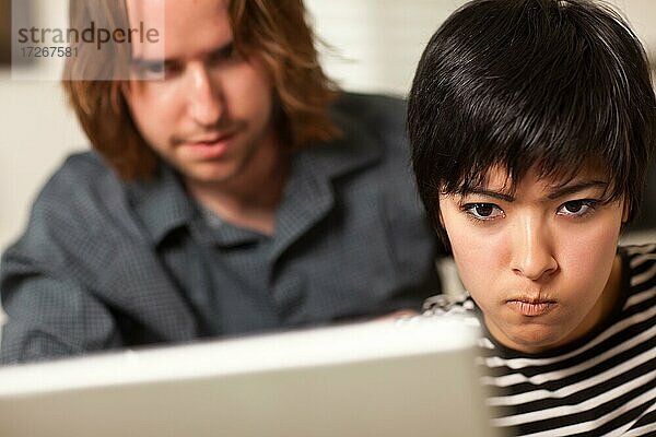 Junger Mann und fleißige Frau mit Laptop-Computer zusammen