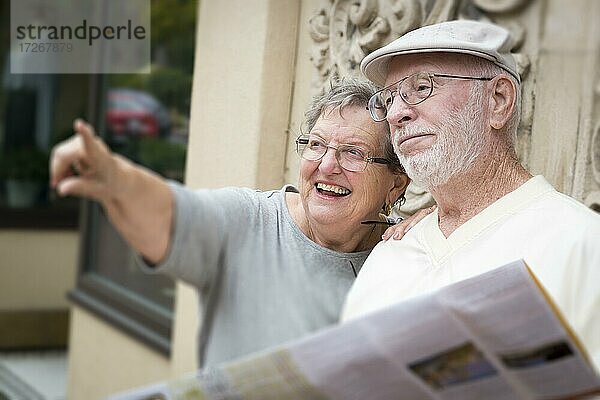Glückliche Touristen Senior Paar Blick auf Broschüre Karte