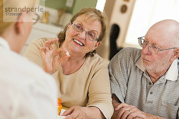 Arzt oder Krankenschwester erklärt einem aufmerksamen Seniorenpaar verschreibungspflichtige Medikamente