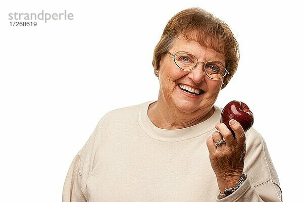 Attraktive ältere Frau mit rotem Apfel vor einem weißen Hintergrund