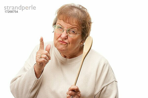 Upset ältere Frau mit dem Holzlöffel vor einem weißen Hintergrund