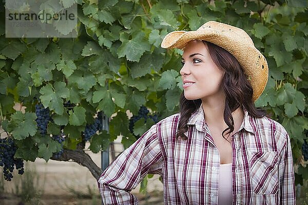 Junges gemischtrassiges erwachsenes weibliches Porträt im Freien mit Cowboyhut in einem Weinberg