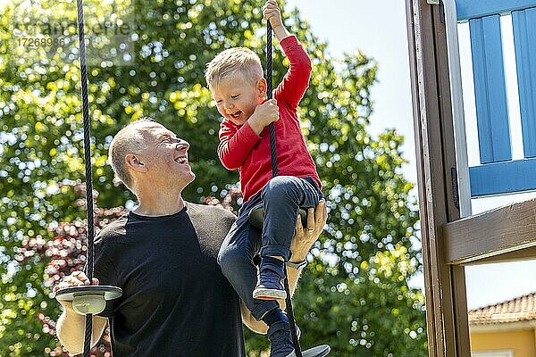 Vater spielt mit seinem 3 Jahre alten Sohn auf dem Spielplatz