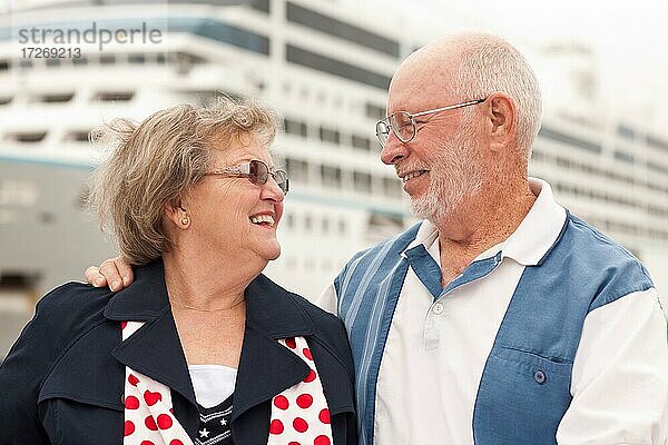 Älteres Paar an Land vor einem Kreuzfahrtschiff im Urlaub