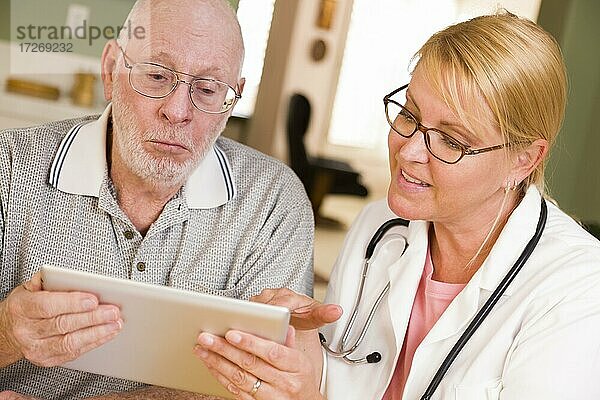 Arzt oder Krankenschwester im Gespräch mit älterem Mann mit Touchpad-Computer