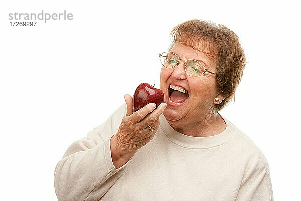 Attraktive ältere Frau mit Apfel vor einem weißen Hintergrund