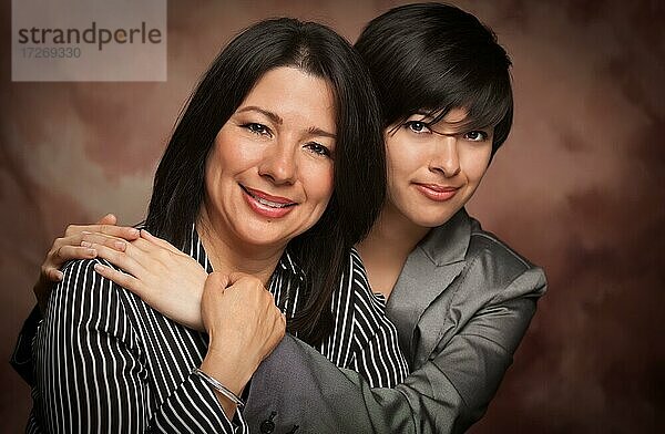 Attraktive multiethnische Mutter und Tochter Studio Porträt auf einem Musselin Hintergrund